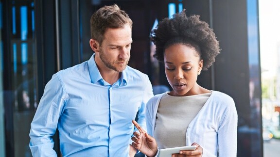 A lady holding the notepad in the hand is having the conversation with a man